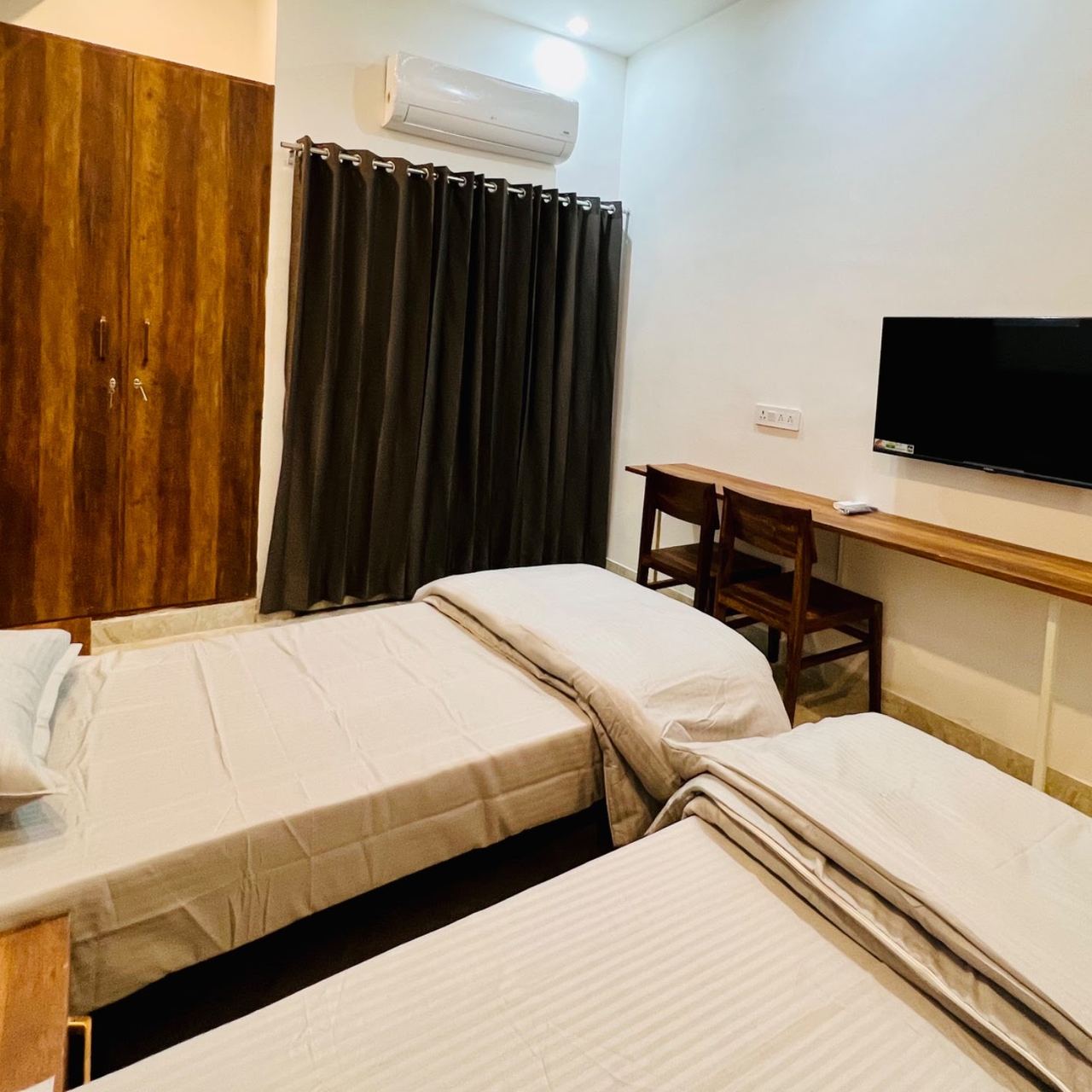 Twin sharing AC room with TV and study desk at Karol's Villa Girls PG, Malviya Nagar