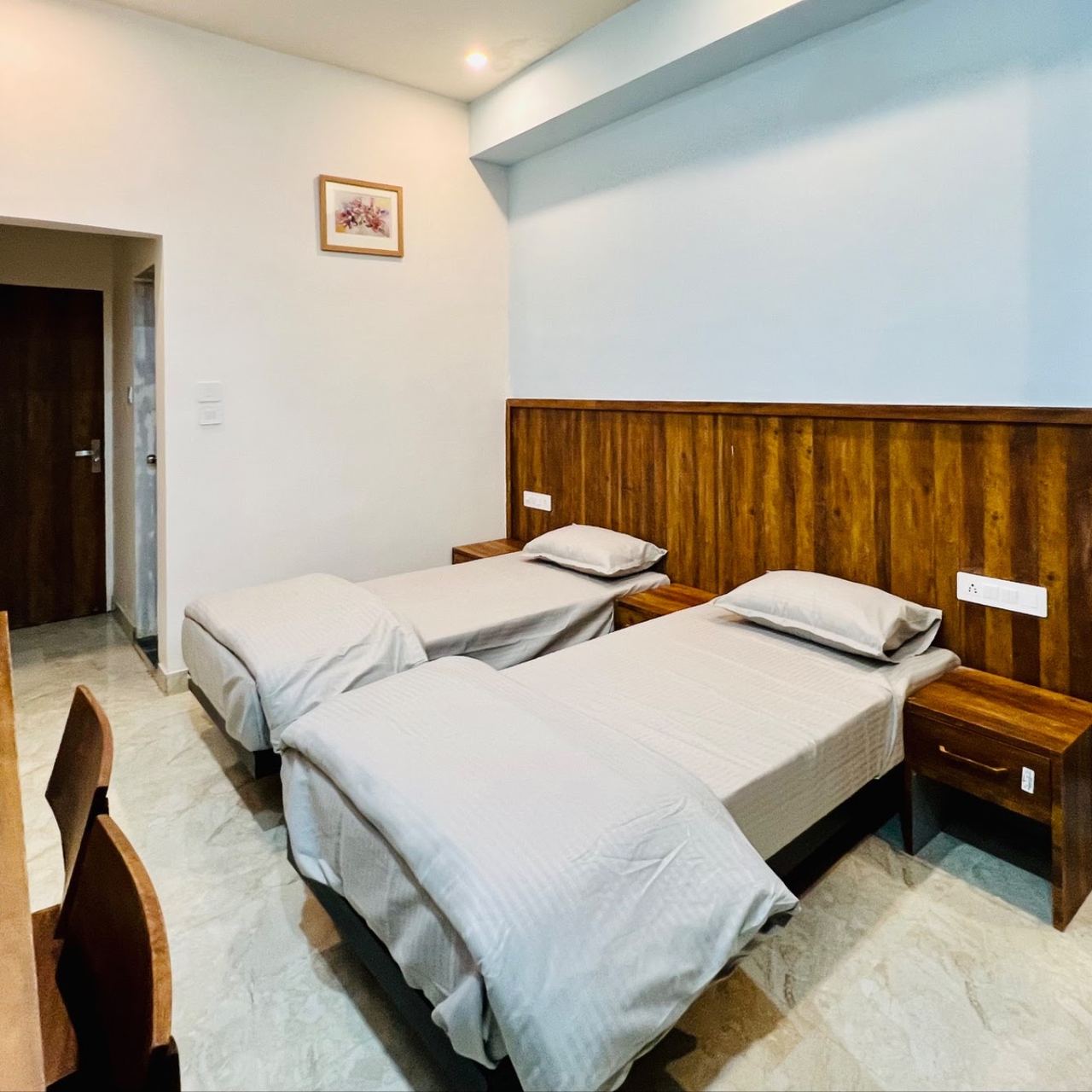 Twin beds with wooden panelling at Karol's Villa Girls PG, Malviya Nagar
